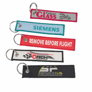 Schlüsselanhänger Stoff Textil Remove before Flight in eignem Design Werbeartikel